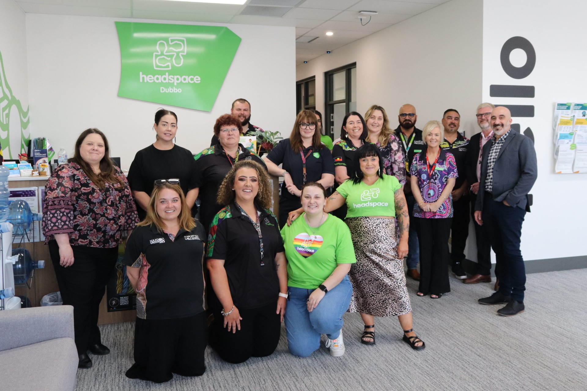 A group of headspace staff, external representatives and the Hon. Emma McBride stand infront of the headspace sign smiling at the camera